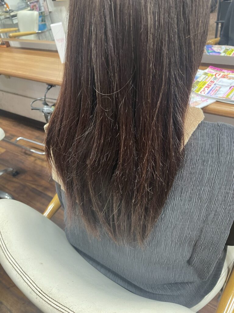 カラサポ施術前の後ろ姿。中間から毛先にゆるやかなうねりが見られる長い髪